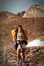 Person with a large backpack standing in a desert landscape